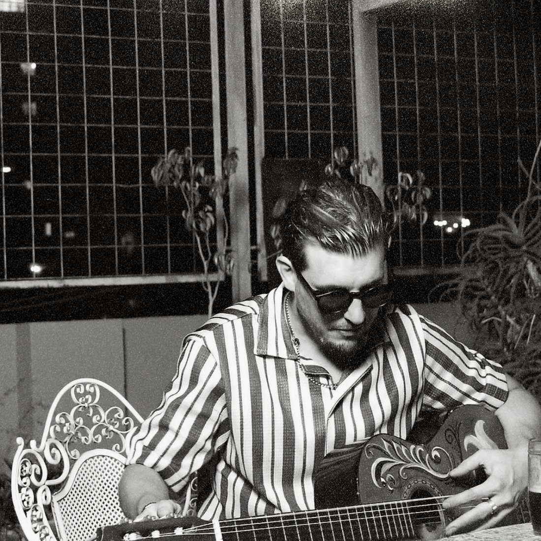 Brunio Who con una guitarra criolla, retrato en blanco y negro